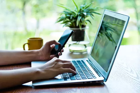 Person surft am Laptop und Handy