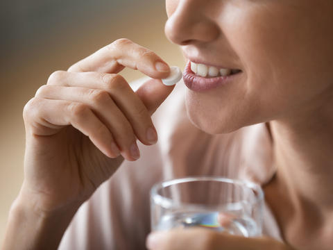 Frau nimmt Refluthin® Kautabletten ein